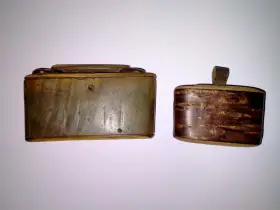 Dwie zabytkowe tabakiery z rogu, jedna z wygrawerowanymi sercami, druga z ozdobnym, drewnianym wzorem.
