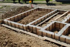 Zbrojenie ławy fundamentowej 40x60 w drewnianym szalunku, gotowe do zalania betonem.