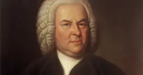 Portret Jana Sebastiana Bacha w peruce i stroju z epoki. Mistrz baroku spogląda z obrazu.