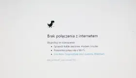 Dinozaur z gry Chrome skacze, bo jest brak internetu. Komunikat "Brak połączenia z internetem" sugeruje sprawdzenie kabli i ponowne połączenie z Wi-Fi.