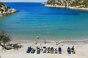 Linia pojazdów terenowych na plaży w Poros, Grecja, czeka na chętnych do zwiedzania. W tle turkusowe morze i skaliste wybrzeże.
