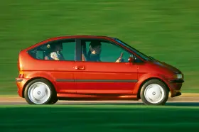 Czerwony samochód elektryczny BMW E1 z lat 90. jadący po zielonym tle.