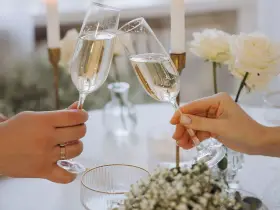 Wznoszenie toastu szampanem. Jakie są zasady serwowania alkoholu na weselu? Wino, wódka czy whisky – wybór należy do pary młodej.