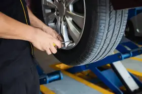 Mechanik sprawdza ciśnienie w oponie. To część usług wulkanizacji, czyli serwisu opon.