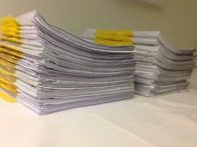 Stosy dokumentów, w tym te z żółtymi przekładkami, czekają na analizę. Kto wydaje orzeczenie o potrzebie kształcenia specjalnego?