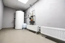Kotłownia z bojlerem, pompami i grzejnikami. Widać tu instalację grzewczą, gdzie separator co zapewnia prawidłowy obieg wody.