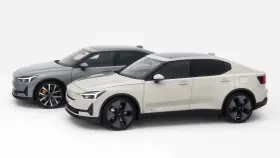 Dwa samochody Polestar 2, jeden biały, drugi szary, stoją obok siebie na białym tle.