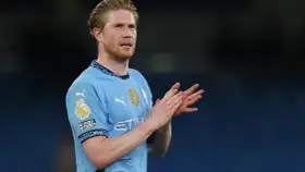 Kevin De Bruyne w błękitnej koszulce Manchesteru City klaszcze, wyrażając uznanie dla kibiców.