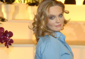 Maria Wiktoria Wałęsa w błękitnej koszuli, z kręconymi blond włosami i niebieskimi oczami, patrzy przez ramię.