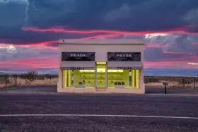Prada Marfa, une installation artistique isolée au Texas, se dresse sous un ciel crépusculaire aux teintes roses et violettes.