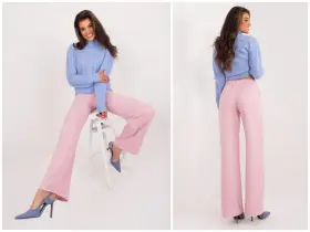 Modelka w pudrowym różu z czym łączyć stylizacje. Szerokie spodnie i błękitny sweterek tworzą elegancki zestaw.