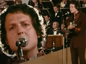 Kto śpiewał "Zegarmistrz światła purpurowy"? To on, z mikrofonem i gitarą, na tle orkiestry.