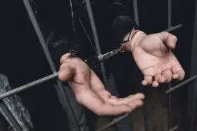 Ręce w kajdankach za kratami. Historia o tym, kiedy policja ściga za alimenty, kończy się zatrzymaniem.