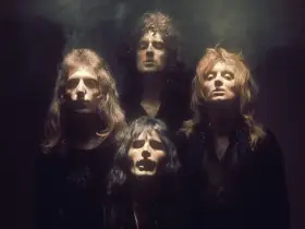 Czterech członków zespołu Queen w mrocznym klimacie, jakby przygotowujących się do wykonania "Bohemian Rhapsody". Ich spojrzenia sugerują głęboką interpretację.