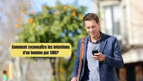 Un homme souriant regarde son téléphone, se demandant comment savoir ce qu'il pense de moi par SMS.