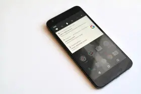 Czarny smartfon z powiadomieniem o pobraniu aktualizacji systemu Android 7.0 Nougat.