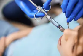 Dentysta podaje znieczulenie miejscowe pacjentowi.