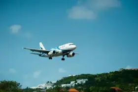 Samolot pasażerski z niebieskimi pasami na tle błękitnego nieba. Może to być przypomnienie o możliwości zwrotu biletu Ryanair zwrot biletu 24h.