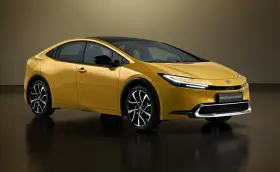 Złoty Toyota Prius Plug-in Hybrid, kiedy nowy prius w polsce, prezentuje się nowocześnie z czarnym dachem i eleganckimi felgami.