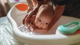 Delikatne kąpiel noworodka w wanience. Czy przy gorączce można kąpać dziecko? Tak, ale w letniej wodzie.