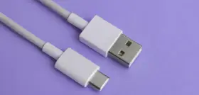 Biały kabel z wtyczkami USB-A i USB typu C na fioletowym tle.