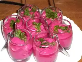 Six verrines de mousse de betterave, garnies de persil frais, prêtes à être dégustées.