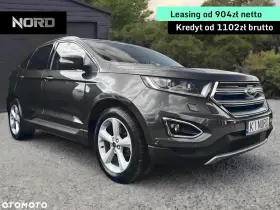Ford Edge 2.0 TDCI w ciemnoszarym kolorze, zaparkowany przed garażem. Oferta leasingu i kredytu.