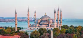 Błękitny Meczet w Stambule, z minaretami górującymi nad miastem i morzem. Czy Istambuł jest bezpieczny? Turyści spacerują pośród pięknej architektury.