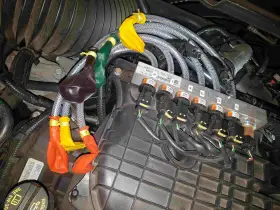 Motorkomponenten mit bunten Ballons an Leitungen. Mögliche Symptome eines defekten Benzinpumpenrelais sind hier zu sehen.