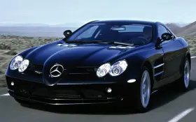 Czarny SLR McLaren pędzi po pustynnej drodze, jego sylwetka lśni w słońcu.