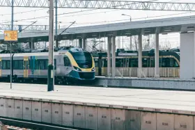 Nowoczesny pociąg Małopolska na stacji. Uważaj na znaki ostrzegawcze, by uniknąć opłaty manipulacyjnej i niebezpieczeństwa.
