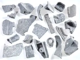 Kawałki metalu, gotowe do recyklingu metalu. Różnorodne kształty i rozmiary, niektóre z otworami, świadczą o ich przemysłowym pochodzeniu.