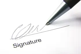 A pen signs a document, finalizing a corporate sponsorship agreement.