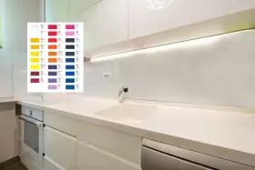 Próbnik kolorów płyty laminowanej nad blatem kuchennym, obok białych szafek.