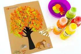 Une peinture automne facile avec un arbre aux feuilles colorées, des animaux et des champignons. Des cotons-tiges et des peintures sont prêts pour créer.