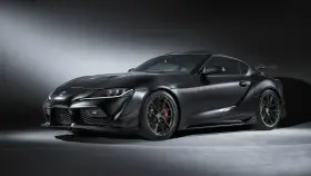 Matowa czerń podkreśla agresywną sylwetkę sportowego coupe Toyota GR Supra. Widoczne czerwone zaciski hamulcowe i aerodynamiczne dodatki.
