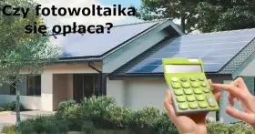 Dom z panelami fotowoltaicznymi na dachu. Obok kalkulator, sugerujący opłacalność inwestycji w fotowoltaikę w domu.