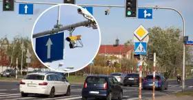 Widok na skrzyżowanie z sygnalizacją świetlną i znakami drogowymi. W powiększeniu widać kamery rejestrujące przejazd na czerwonym świetle.