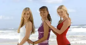 Trzy dziewczyny z obsady "H2O – wystarczy kropla" na plaży.