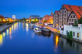 Bydgoszcz: rzeka Brda, łodzie, zabytkowe kamienice i rzeźba na linie. Nietypowe atrakcje Bydgoszcz zachwycają o zmierzchu.