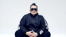Marek "Mrozu" Mróz w okularach i czarnej kurtce z napisem "GETTA", jakby szykował się na koncert zespołu Munka Staszczyka.