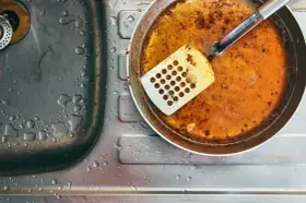 Zlepek zużytego oleju gastronomicznego na patelni obok zlewu.
