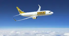 Samolot Buzz, należący do Ryanair, leci nad chmurami. Idealny na wakacje, zabierze Twój bagaż w słoneczne miejsce.