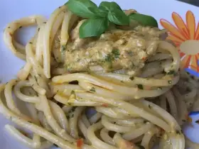 Un piatto invitante di pasta alla carlofortina, condita con un sugo cremoso e guarnita con basilico fresco.