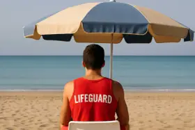 Giovane bagnino sorveglia la spiaggia, un'idea per lavori estivi per minorenni.