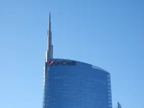 Szklany wieżowiec UniCredit z charakterystycznym logo, sięgający ku błękitnemu niebu. To symbol nowoczesności, jakby z przyszłości, niczym z wizji Aion Bank.