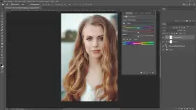 Portret młodej kobiety z falującymi włosami, edytowany w programie graficznym. Panel "Farbton/Sättigung" sugeruje, że zastosowano efekt **high key**.