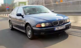 Niebieskie BMW serii 5 (E39) z silnikiem m52b20 jedzie po moście.