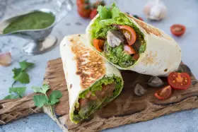 Piadina con pesto, pomodoro e lattuga, un pasto fresco e saporito.