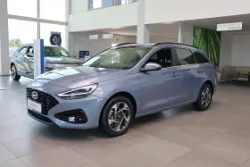Niebieski Hyundai i30 Wagon z 2015 roku stoi w salonie samochodowym.